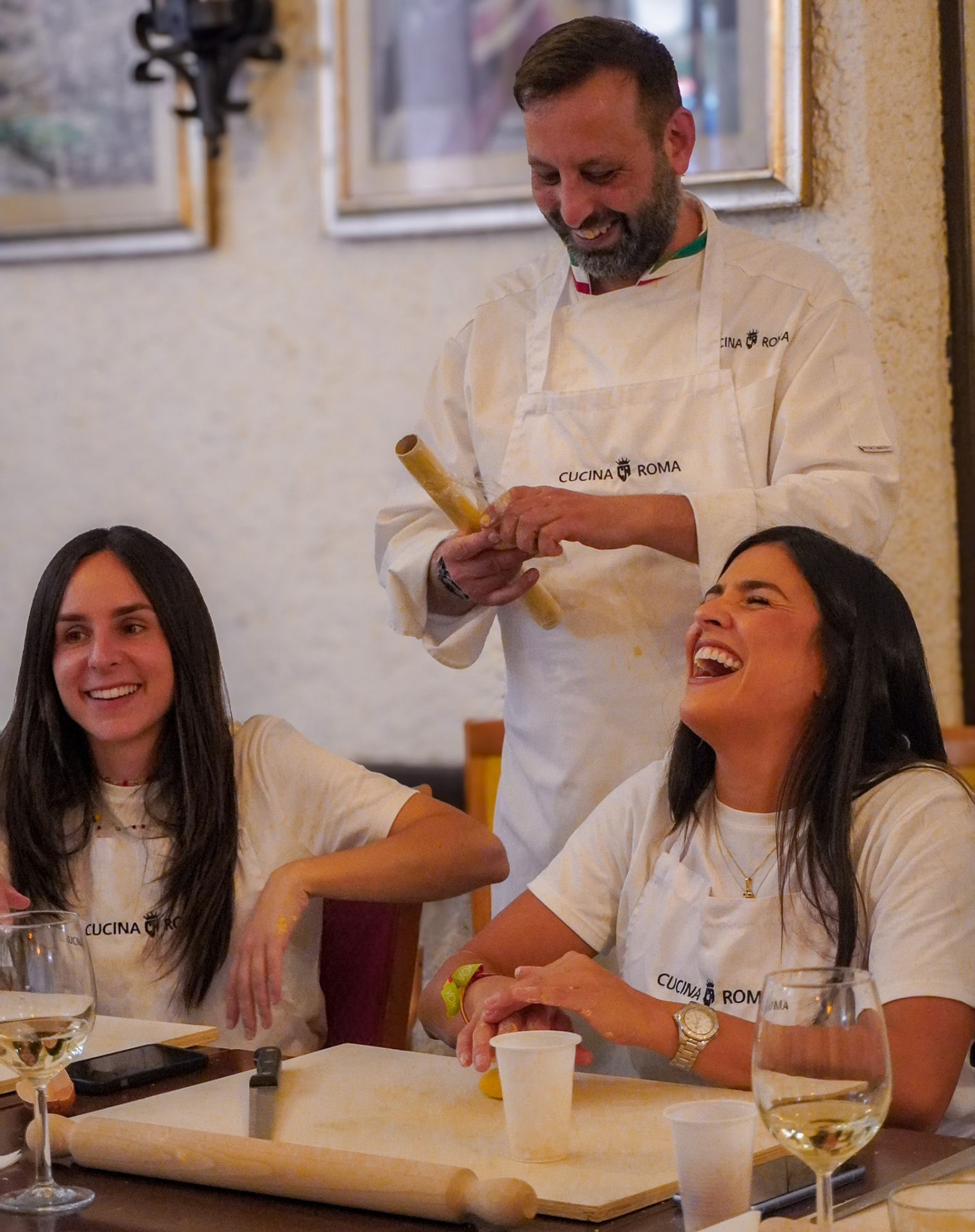 Lo chef di Cucina Roma insegna a stendere la pasta fresca tra le risate dei partecipanti