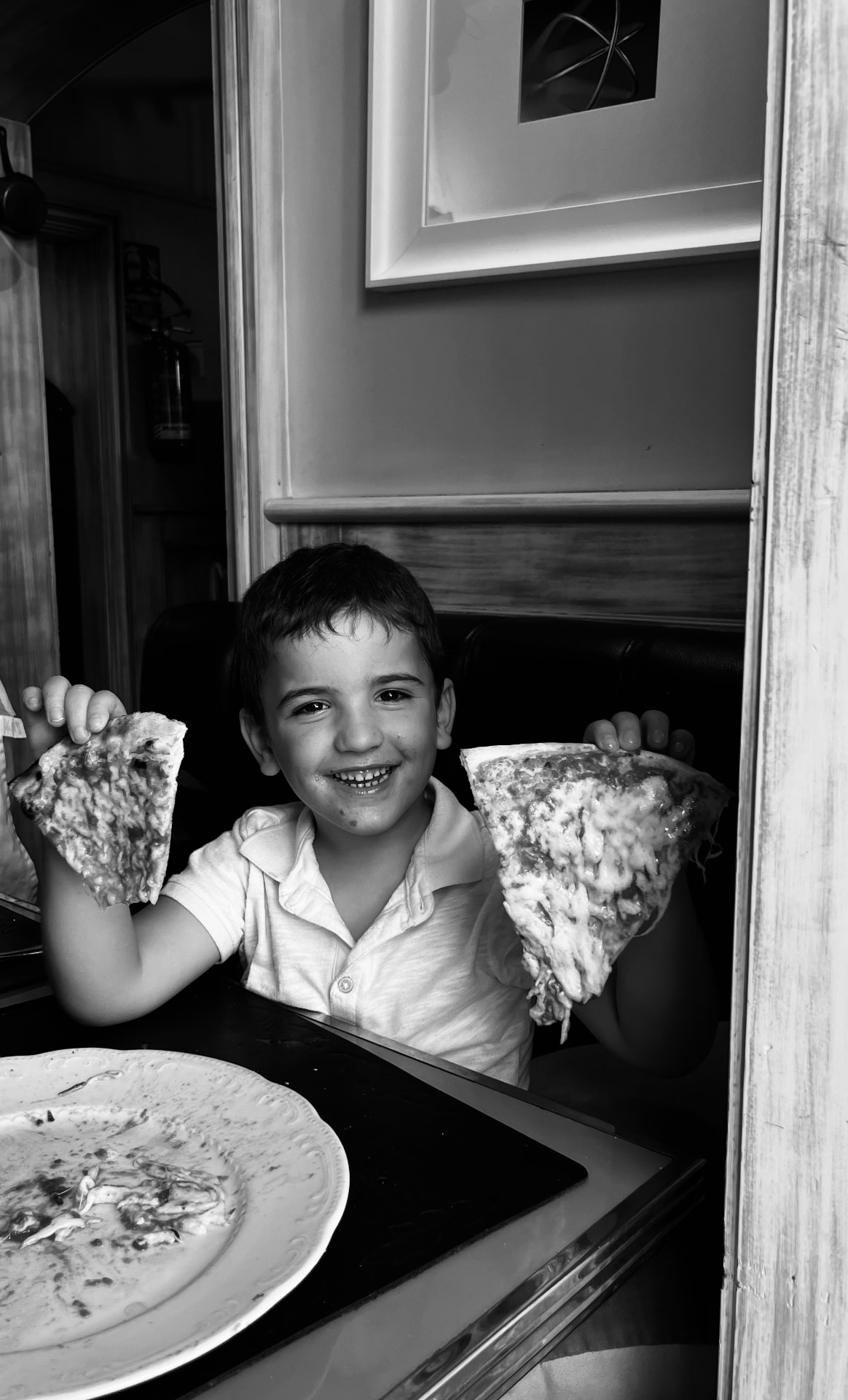 Bambino felice con due fette di pizza fatta a mano durante la pizza class a Roma